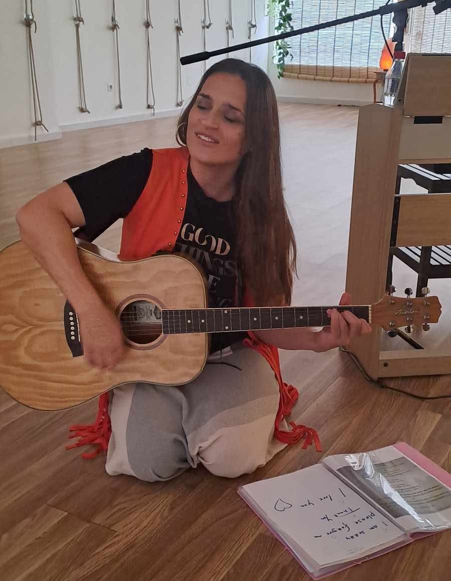 Liz Leila facilitating music with an acoustic guitar